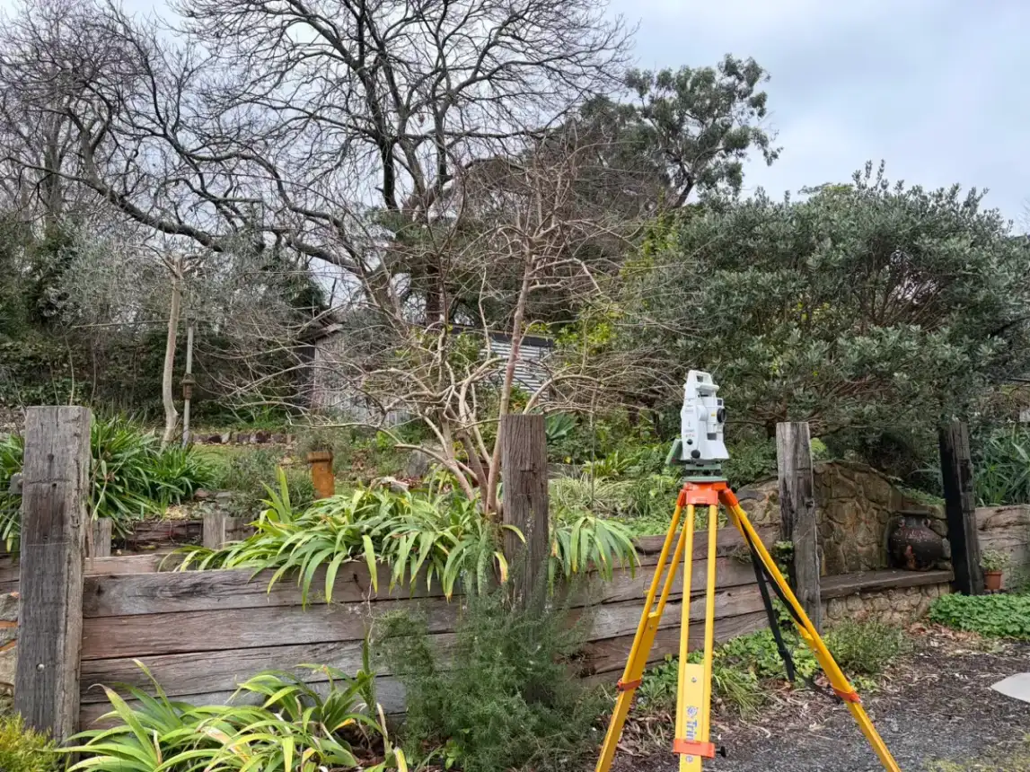 Survey tripod beside a retaining wall