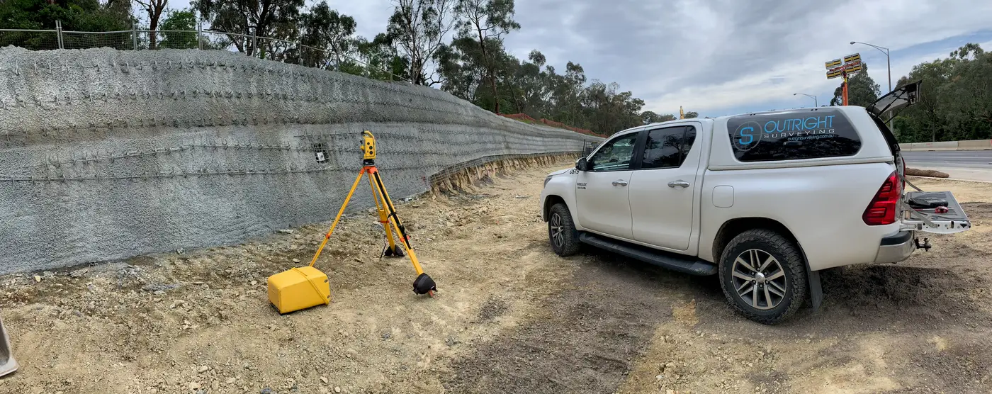 Survey set up against a shotcrete retaining wall